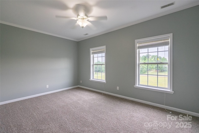 carpeted empty room featuring ceiling fan, baseboards, and crown molding