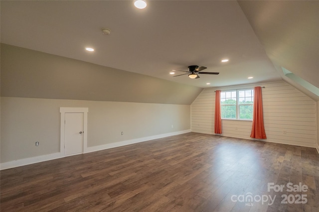 additional living space featuring dark wood finished floors, a ceiling fan, vaulted ceiling, baseboards, and recessed lighting