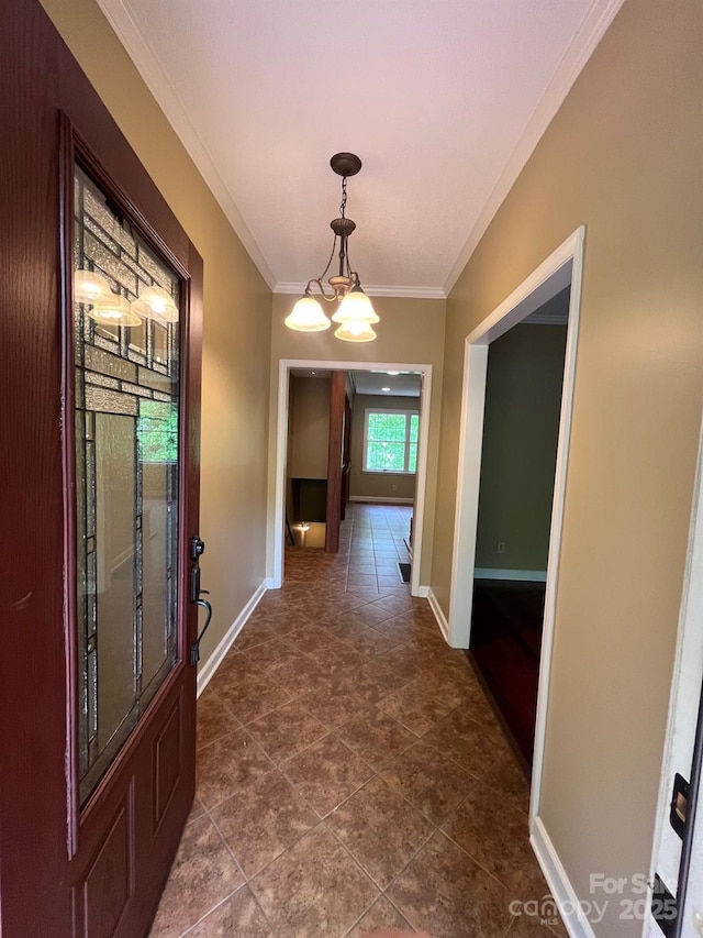 hallway with crown molding, baseboards, and a notable chandelier