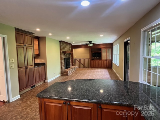 kitchen featuring recessed lighting, a ceiling fan, baseboards, and a fireplace
