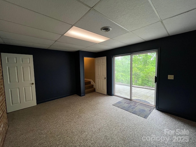 unfurnished room featuring visible vents, stairs, baseboards, a paneled ceiling, and carpet flooring