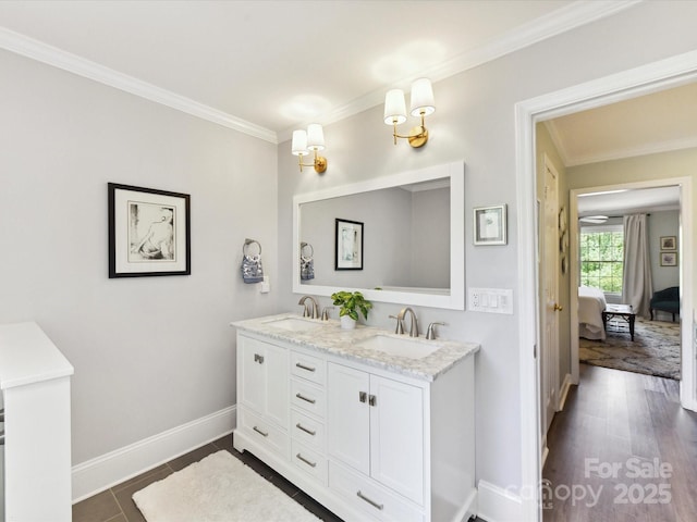 full bathroom featuring connected bathroom, double vanity, ornamental molding, and a sink