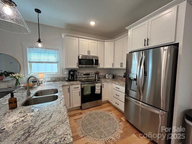 24 Wheeler Rd, Weaverville, NC 28787 - kitchen with stainless steel appliances, a sink, white cabinetry, light wood finished floors, and light stone counters
