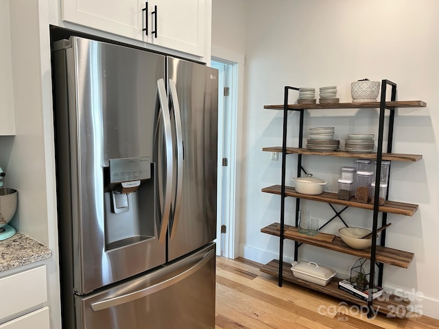 24 Wheeler Rd, Weaverville, NC 28787 - kitchen with stainless steel fridge with ice dispenser, light wood finished floors, white cabinetry, baseboards, and light stone countertops