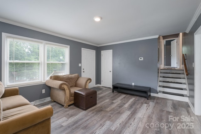 living room with baseboards, ornamental molding, and wood finished floors