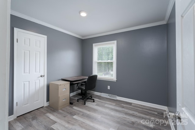 office space featuring crown molding, light wood-style flooring, baseboards, and visible vents