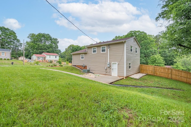 back of house featuring a lawn, a patio, and fence