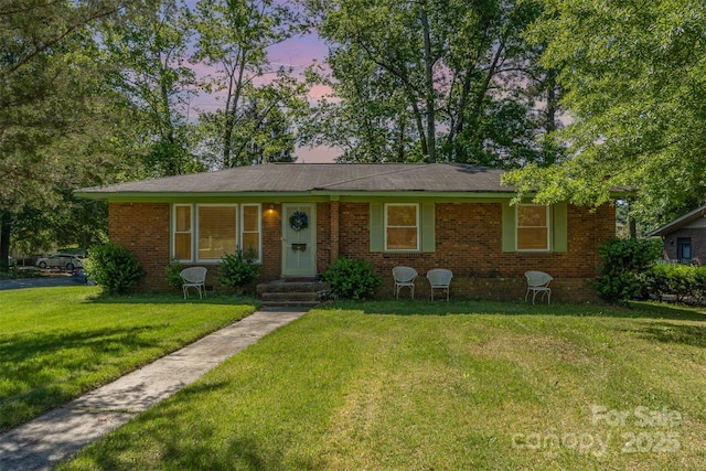 single story home featuring brick siding and a front lawn