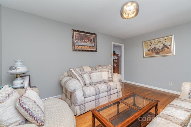 living area with baseboards and wood finished floors