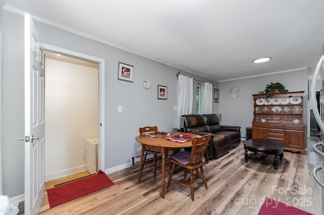 dining area featuring light wood-style floors, baseboards, and crown molding