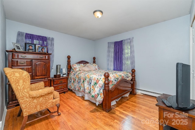 bedroom featuring light wood finished floors and a baseboard radiator