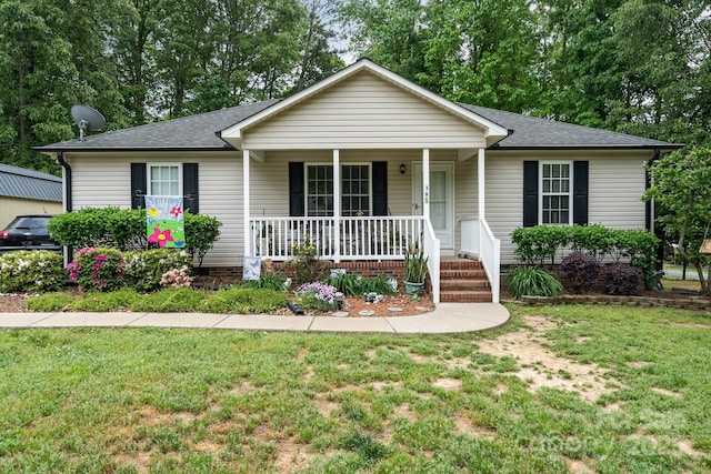 ranch-style house with a porch, roof with shingles, and a front lawn