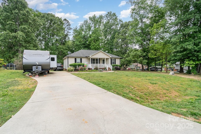 view of front of house with concrete driveway, covered porch, and a front yard