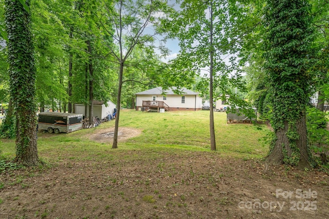 view of yard with a deck and an outbuilding