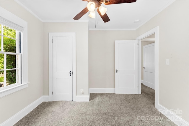 unfurnished bedroom featuring baseboards, ornamental molding, carpet, and ceiling fan