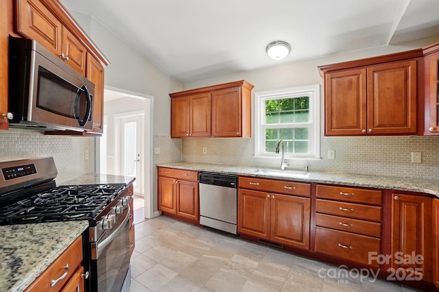 2379 Whitley Rd, Fort Mill, SC 29708 - kitchen with stainless steel appliances, a sink, decorative backsplash, brown cabinetry, and vaulted ceiling