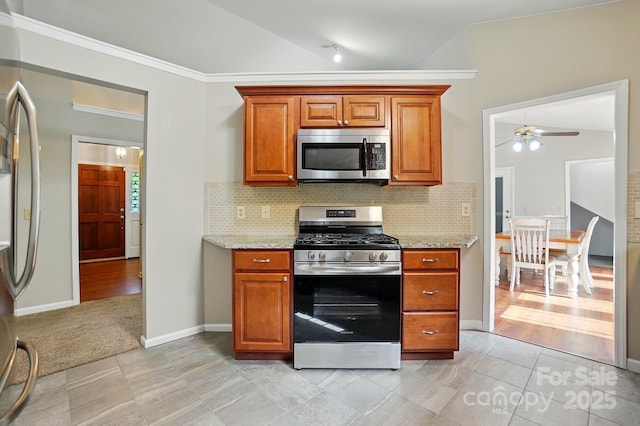 2379 Whitley Rd, Fort Mill, SC 29708 - kitchen with stainless steel appliances, brown cabinets, ceiling fan, backsplash, and light stone counters
