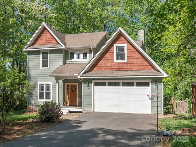 craftsman-style home with a chimney, roof with shingles, a garage, fence, and aphalt driveway
