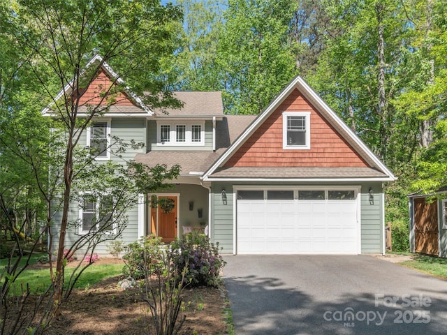 view of front of house with an attached garage, a shingled roof, and driveway