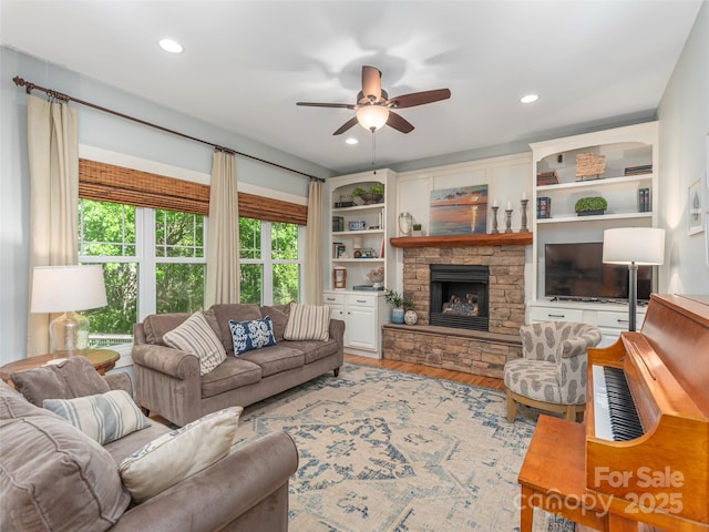 living area with a ceiling fan, recessed lighting, wood finished floors, and a fireplace