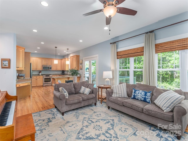 living room with recessed lighting, a ceiling fan, and light wood-style flooring