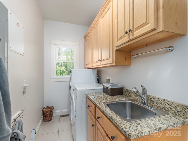 laundry area with cabinet space, light tile patterned flooring, washer and dryer, a sink, and baseboards