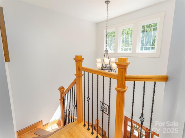 staircase featuring a notable chandelier