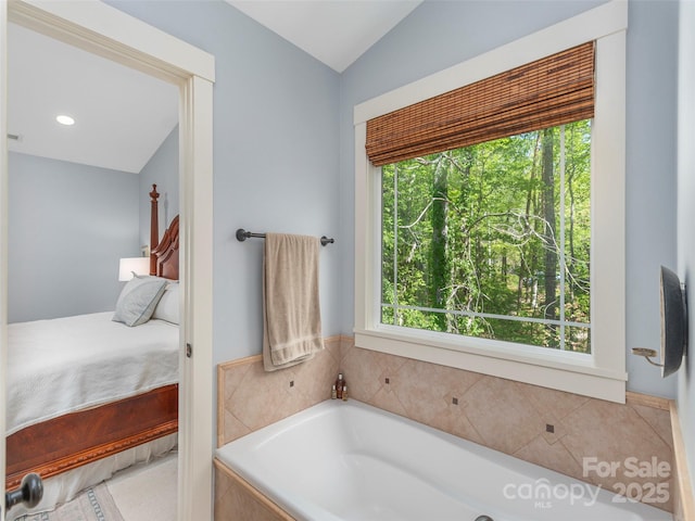 ensuite bathroom with a garden tub, ensuite bath, a healthy amount of sunlight, and vaulted ceiling