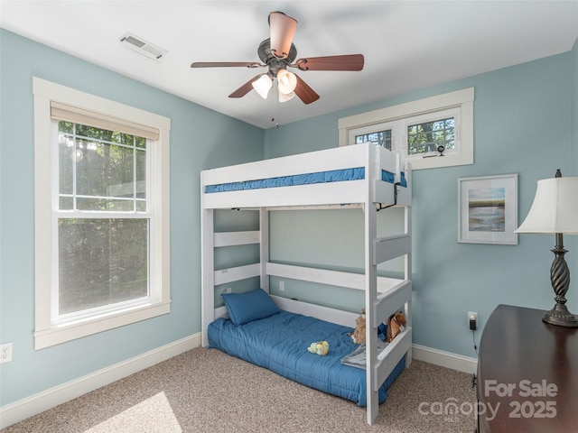 carpeted bedroom featuring baseboards, ceiling fan, and visible vents