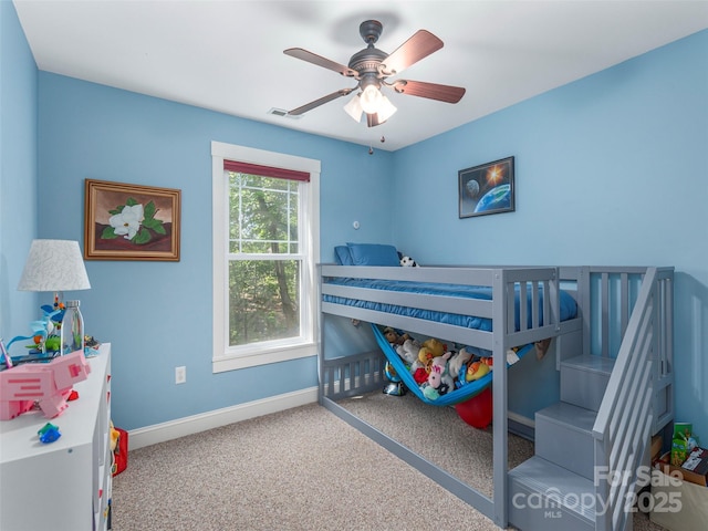 carpeted bedroom with a ceiling fan, baseboards, and visible vents