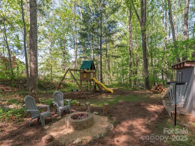 view of yard with a playground and a fire pit