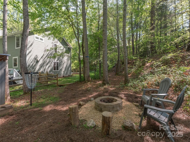 view of yard with fence and a fire pit