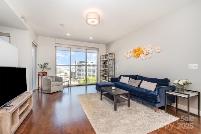 living room featuring dark wood-style flooring, baseboards, and recessed lighting