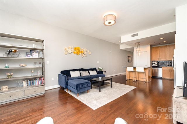 living area featuring baseboards, dark wood finished floors, and visible vents