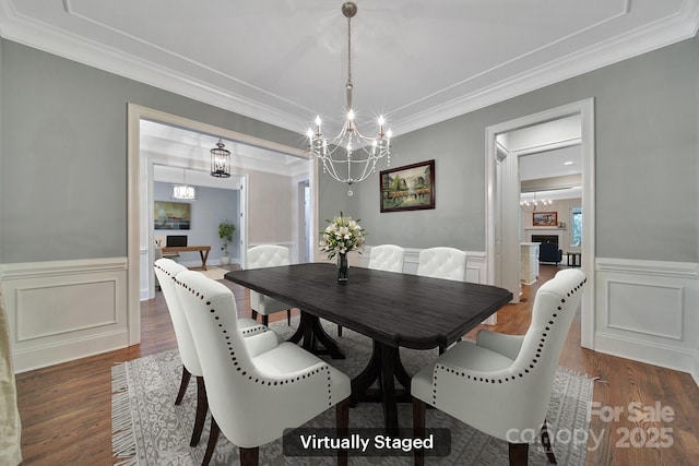 128 Spears Creek Dr, Mooresville, NC 28117 - dining area featuring a chandelier, dark wood finished floors, ornamental molding, wainscoting, and a decorative wall