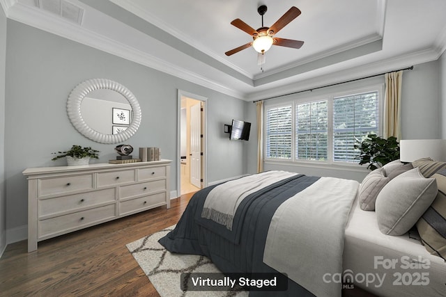 128 Spears Creek Dr, Mooresville, NC 28117 - bedroom with dark wood-type flooring, ornamental molding, a tray ceiling, baseboards, and ensuite bath