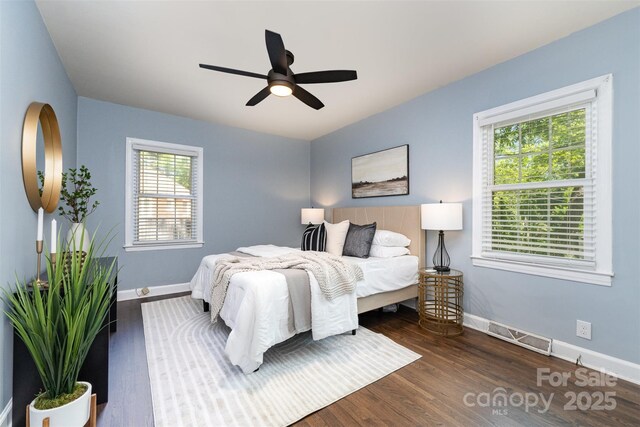 bedroom featuring baseboards, ceiling fan, wood finished floors, and visible vents