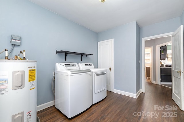 washroom featuring laundry area, washing machine and clothes dryer, baseboards, water heater, and dark wood-type flooring