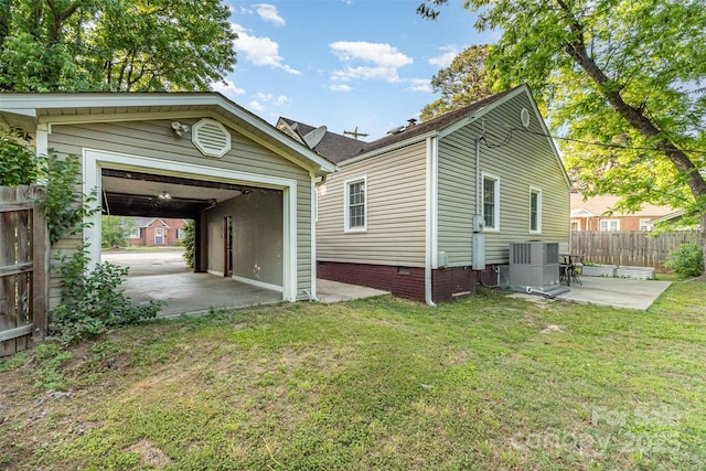 exterior space with fence, crawl space, central AC unit, a patio area, and a yard