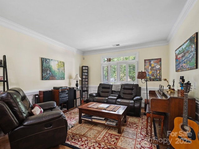 living area with visible vents, ornamental molding, and wainscoting