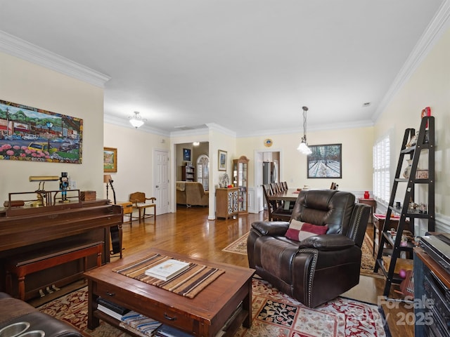 living room with crown molding and wood finished floors