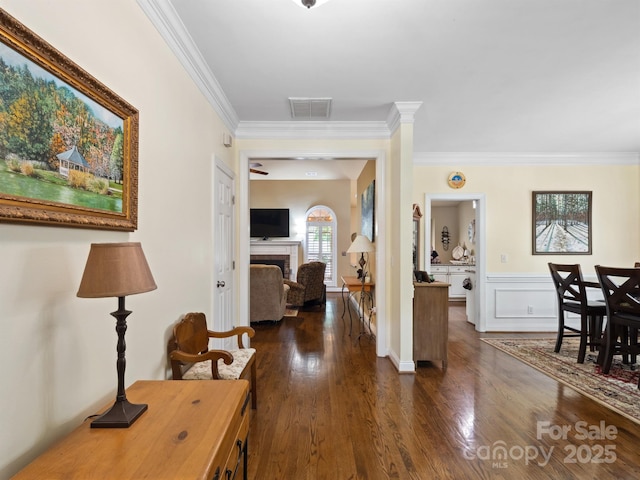 hall with crown molding, dark wood-type flooring, and visible vents