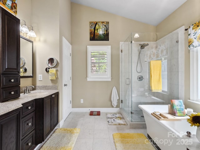 bathroom with vanity, a freestanding tub, baseboards, a stall shower, and vaulted ceiling