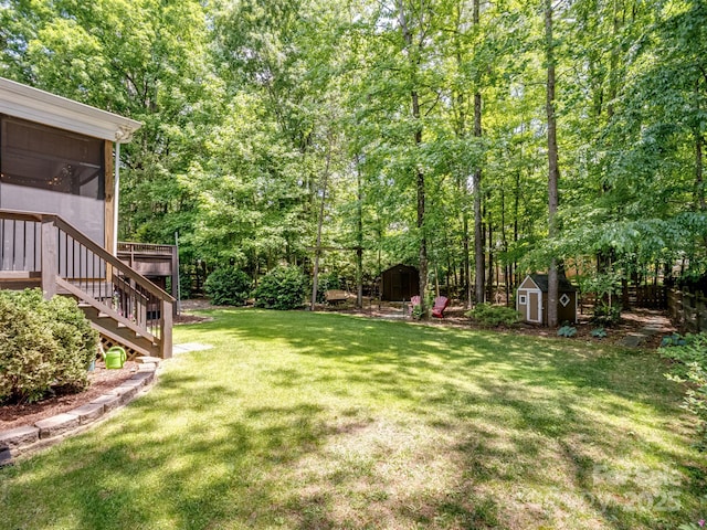 view of yard featuring a storage shed, a sunroom, an outdoor structure, and stairs