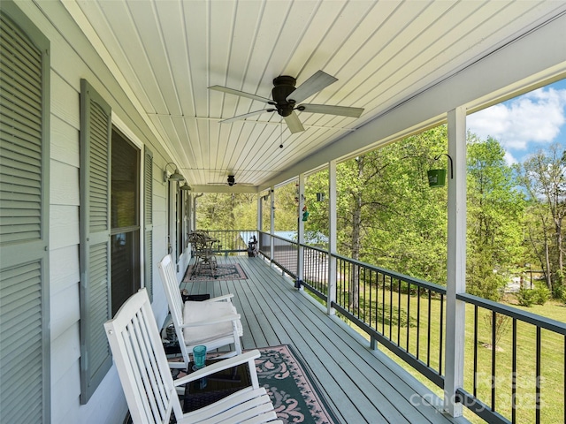 wooden terrace featuring a ceiling fan and a porch