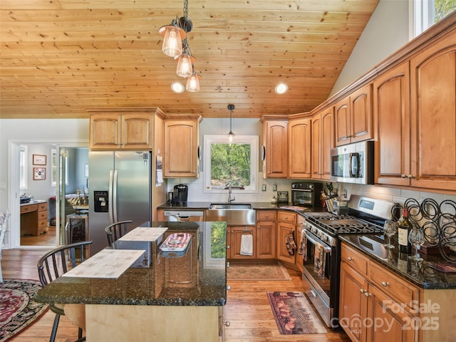 kitchen with appliances with stainless steel finishes, a sink, wooden ceiling, dark stone countertops, and light wood-style flooring