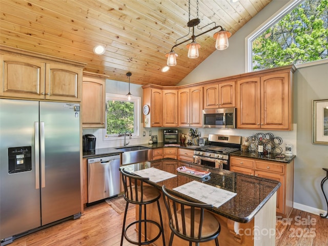 kitchen featuring decorative backsplash, dark stone counters, wood ceiling, light wood finished floors, and stainless steel appliances