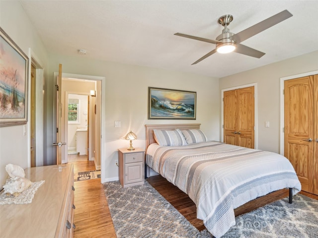 bedroom with ceiling fan, baseboards, and light wood finished floors