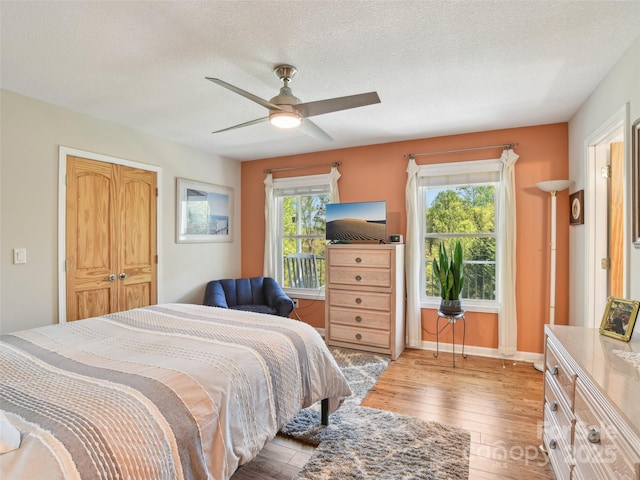 bedroom featuring wood-type flooring, a textured ceiling, and ceiling fan