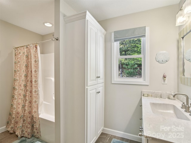 bathroom featuring baseboards, vanity, and shower / tub combo